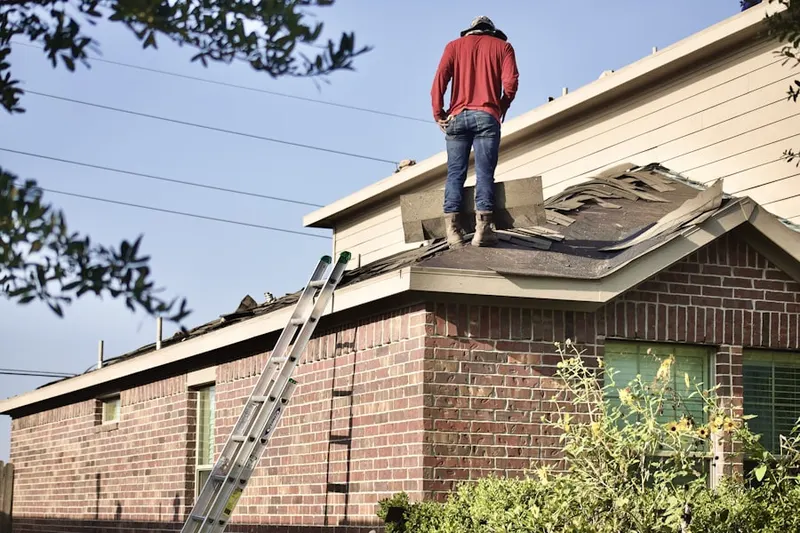 Professional roofer working on a residential roof in Blair Mill Village East